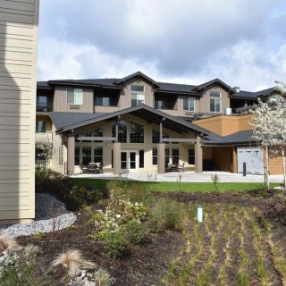 A modern residential building with landscaped gardens and a spacious front entrance.