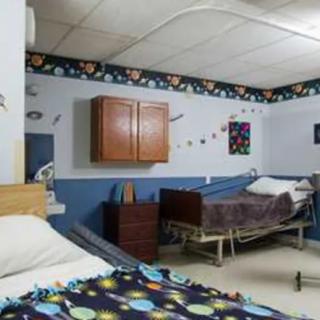 A hospital room with two beds and medical equipment.