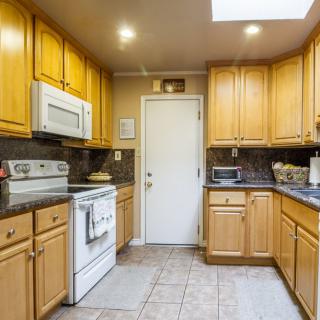 A cozy kitchen with wooden cabinets and modern appliances.