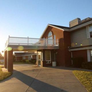 A two-story residential building with a driveway, captured during sunset.