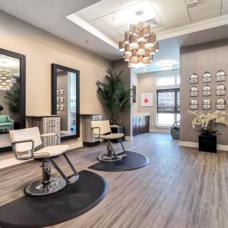 A modern salon interior with stylish chairs and mirrors, complemented by contemporary lighting.