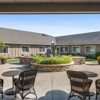 A tranquil courtyard with a central fountain, surrounded by seating and lush landscaping.