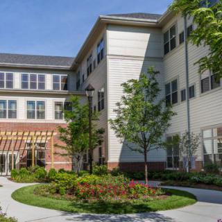 A modern building with large windows and landscaped greenery.