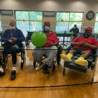 Seniors enjoying a recreational activity in a community center, engaging with each other while participating in a game.