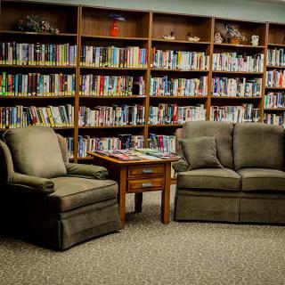 Cozy reading nook in a library with bookshelves and comfortable seating.