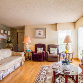 A cozy living room with a sofa, two armchairs, and a coffee table on a wooden floor.