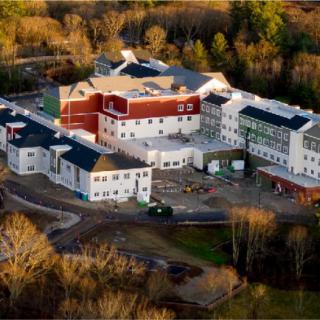 An aerial view of a large building complex surrounded by trees.