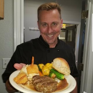 A chef proudly presenting a delicious meal.