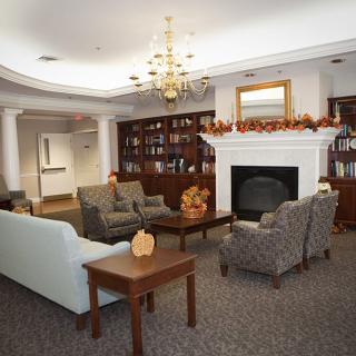 A cozy living room with comfortable seating, a fireplace, and bookshelves.