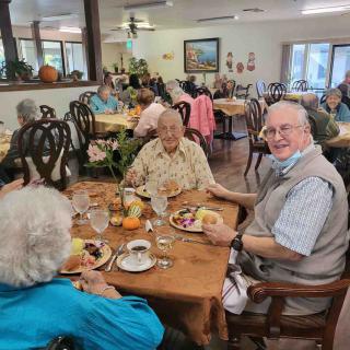 A group of elderly people enjoying a meal together in a dining area.