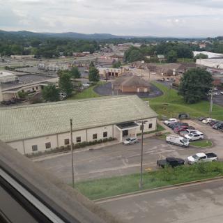 A view of a small town showing various buildings and green landscapes in the background.