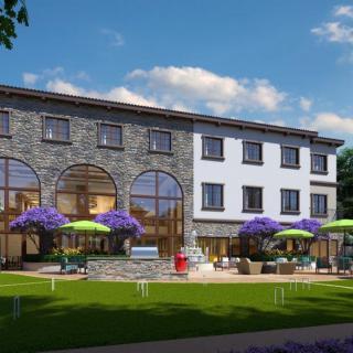 A sunny day at a modern building with outdoor seating and vibrant umbrellas.