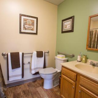 A clean and neat bathroom with a toilet, sink, and towels.