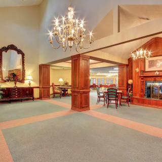Spacious lobby area with elegant chandelier and classic wood paneling.