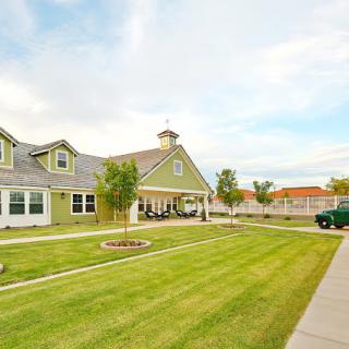 A suburban house with a well-maintained lawn and clear skies.