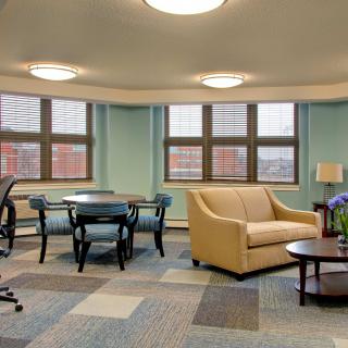 A modern office lounge area with comfortable seating and large windows.
