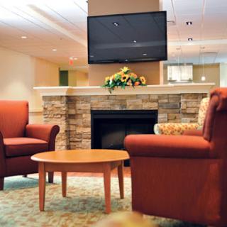 A cozy living room featuring comfortable seating, a fireplace, and a television.