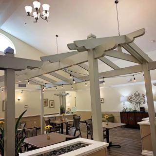 A well-lit indoor dining area with chandeliers, tables, and decorative elements.