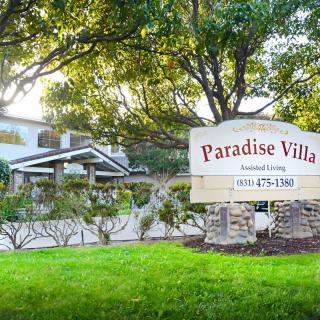 Paradise Villa assisted living facility with a landscaped garden and a welcoming sign.