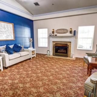 A cozy living room with a blue accent wall, featuring a sofa and a fireplace.