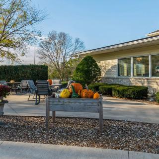 A cozy outdoor patio decorated with pumpkins and seasonal decorations, capturing the essence of autumn.