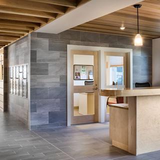A modern office interior featuring a wooden reception desk and sleek design elements.