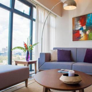 A modern living room with a comfortable sofa, stylish coffee table, and colorful artwork.