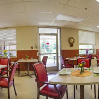 A cozy dining area with red chairs and neatly set tables, inviting for a meal.