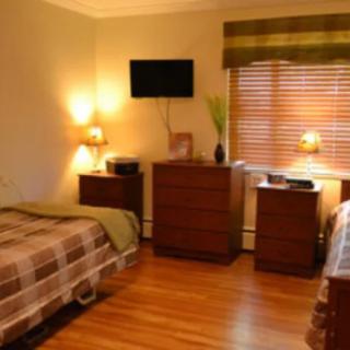 A cozy bedroom with twin beds, wooden flooring, and warm lighting.