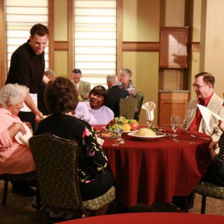 A group of people enjoying a meal together in a restaurant setting.