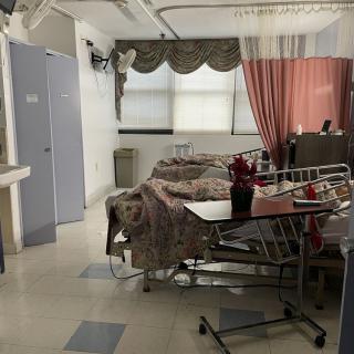 A hospital room with beds and medical equipment.