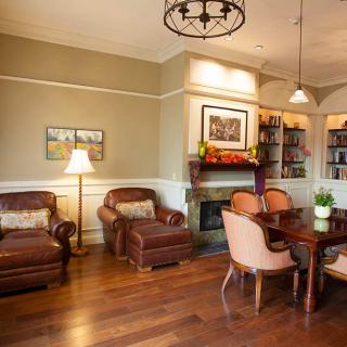 A cozy living room with armchairs, a dining table, and a fireplace.