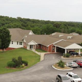 Aerial view of a residential or hospitality building surrounded by greenery.