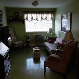 A cozy living room featuring soft green walls and comfortable seating.