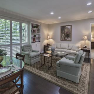A cozy and elegantly furnished living room featuring a sofa, armchairs, a coffee table, and tasteful decor.