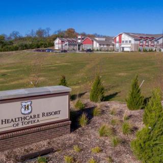 A healthcare facility with well-maintained landscaping and a visible sign in the foreground.