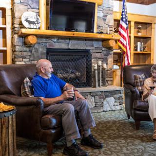 Two individuals enjoying a conversation in a cozy lounge setting.