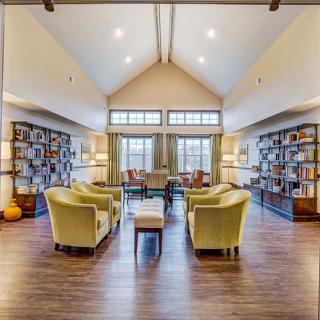 A cozy library reading room with bookshelves and comfortable seating.