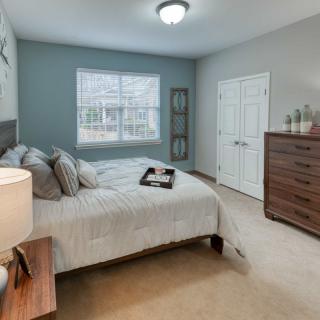 A cozy, well-decorated bedroom with a double bed, dresser, and soft lighting.