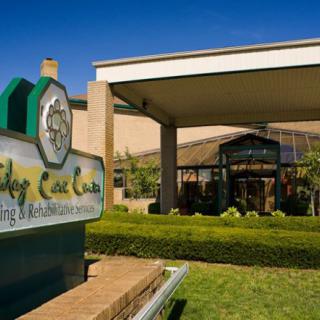 Entrance of a golf club with prominent signage and well-maintained landscaping.