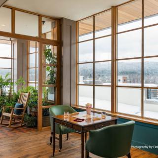 Cozy dining area with large windows letting in natural light.