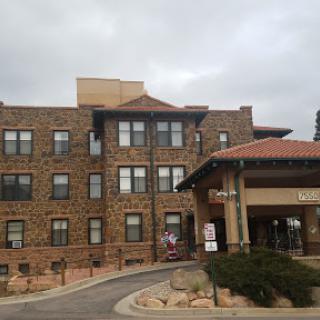 A view of a residential building showcasing classic brick architecture under a cloudy sky.