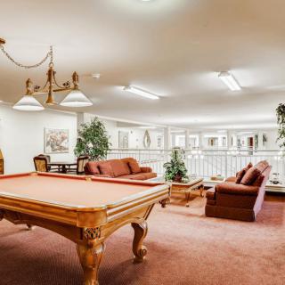 A spacious game room featuring a billiards table and comfortable seating.