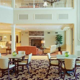 A spacious living and dining area with comfortable seating, featuring a cozy fireplace and elegant decor.