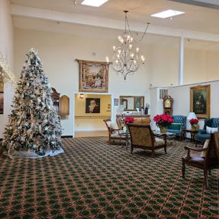 A cozy lobby decorated for the holiday season, featuring a beautifully adorned Christmas tree and elegant furnishings.