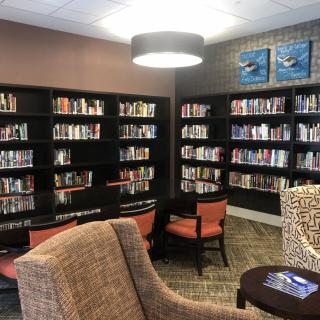 A cozy reading nook with bookshelves and comfortable seating in a library.