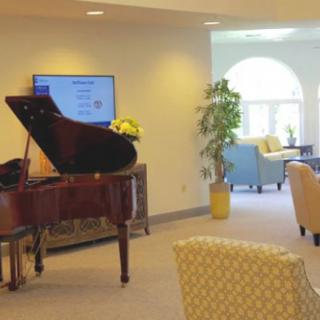 A cozy living room with a grand piano and comfortable seating area.