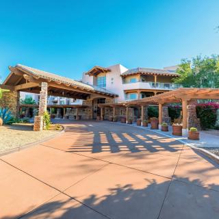 A beautiful hotel entrance with rustic architecture on a sunny day.