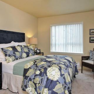 A cozy bedroom with floral bedding and elegant decor.
