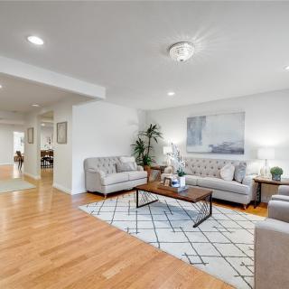 A modern living room with contemporary furnishings, featuring two sofas, a coffee table, and hardwood floors.